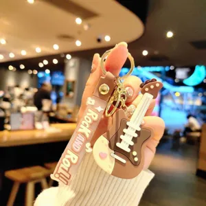 Detailopname van een creatieve PVC gitaar sleutelhanger met coole slogan band en ring.