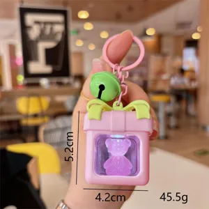 Detalle de llavero de oso luminoso lindo, colgante de caja de regalo rosa con luz LED para bolsos.