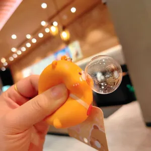 Close-up of a cute orange squeeze bubble toy keychain, soft stress relief accessory.