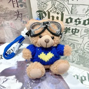 Porte-clés en peluche douce avec lunettes de soleil et pull bleu vue de détail.