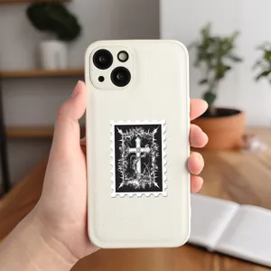Dettaglio dell'adesivo con croce gotica su cover in pelle bianca, stile scuro.