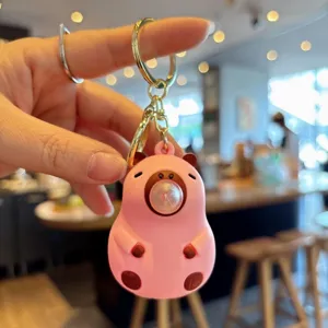 Cute cartoon blowing bubbles capybara keychain pendant, adorable animal car key ring toy.