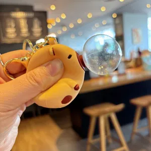 Close-up detail of cute capybara blowing bubble keychain, stress relief toy charm pendant.