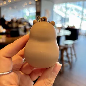 Detail shot of cute brown capybara silicone keychain pendant, showing soft texture and metal ring.