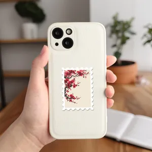 Vista dettagliata di una custodia per cellulare in pelle bianca con adesivo di fiori di pruno.
