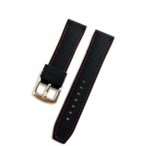 Detalle de correa de reloj de silicona negra, deportiva impermeable con costuras rojas y hebilla.