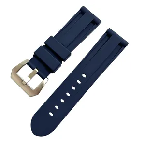 Detalle de correa de reloj de silicona azul oscuro con hebilla metálica y múltiples agujeros.