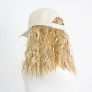 Vue détaillée d'une casquette de baseball beige avec perruque blonde longue et ondulée.