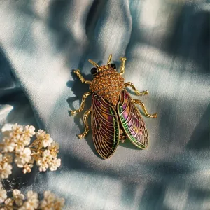 Close-up of vintage rhinestone cicada brooch, exquisite metal and colorful enamel wings.