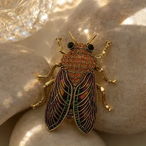 Vintage rhinestone cicada brooch, elegant gold-tone insect lapel pin, stylish apparel accessory.