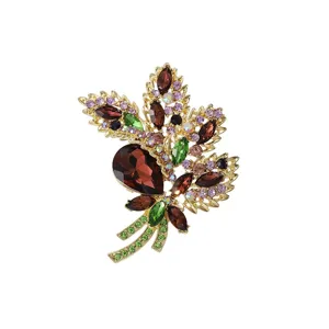 Close-up detail of the crystal brooch featuring colorful rhinestones and delicate metal leaves.