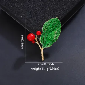 Elegant enamel leaf and red berry brooch pin, exquisite metallic accessory for women.