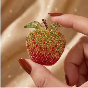 Close-up detail of the stunning gradient rhinestone apple brooch, sparkling colorful crystals.