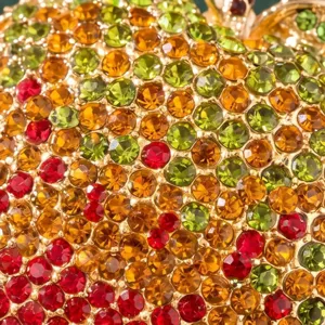 Close-up detail of rhinestone apple brooch, sparkling colorful crystals with gold metal.