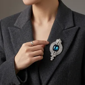 Nahaufnahme einer vintage silbernen Brosche mit glitzernden Steinen und blauem Schmuckstein.