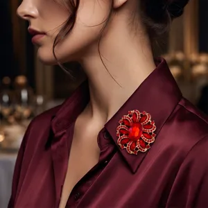 Nahaufnahme der eleganten roten Strass-Blumenbrosche im Detail, glänzendes Kristallaccessoire.