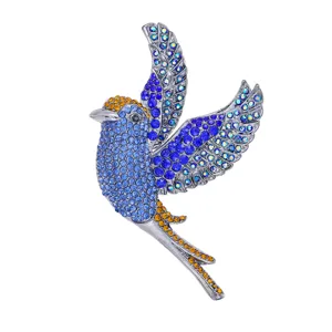 Close-up detail of vintage crystal flying bird brooch sparkling rhinestone accessory.