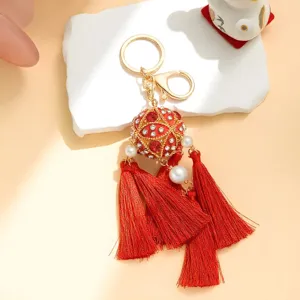 Detailed view of Chinese style red hydrangea rhinestone metal keychain with tassels for bag.