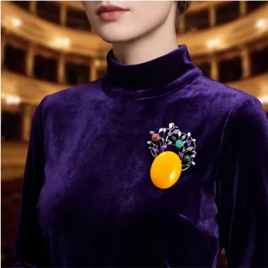Broche vintage en alliage avec grande pierre jaune et branches en argent délicates.