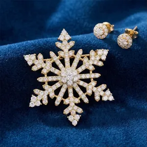 Gros plan d'une broche flocon de neige dorée luxueuse avec des boucles d'oreilles assorties.