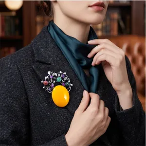 Gros plan détail de la broche vintage avec pierre imitation ambre et pierres précieuses.