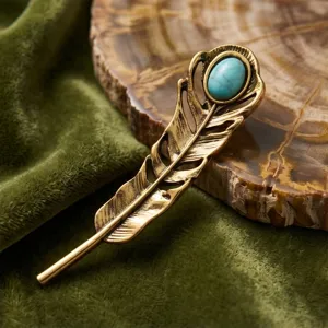 Vintage bronze feather brooch with turquoise stone, elegant retro clothing accessory for stylish outfits.