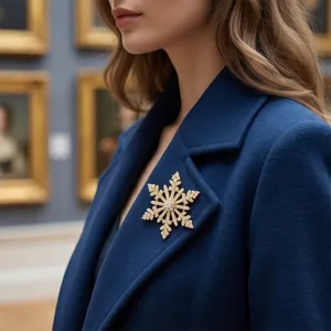Gros plan d'une broche flocon de neige en or avec strass sur manteau bleu.