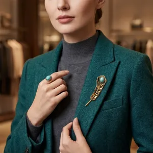 Vintage feather brooch and turquoise ring set, elegant suit jacket accessory for stylish look.