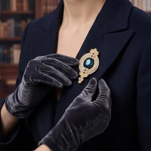 Detailaufnahme der exquisiten Vintage Strass und blauen Edelstein Brosche am Anzug.