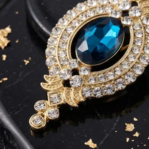 Antike goldfarbene Strass-Brosche mit großem ovalem blauen Kristall für elegante Anzüge.