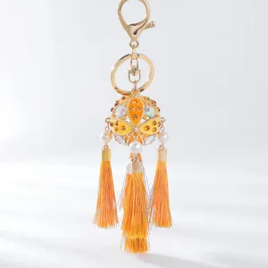 Close-up detail of the elegant orange rhinestone hydrangea keychain with vibrant tassels.