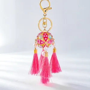 Gold alloy rhinestone embroidered ball bag charm with pink tassels for car keys detail.