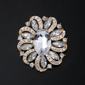 Gros plan d'une broche florale dorée de luxe étincelante avec des cristaux de strass transparents.