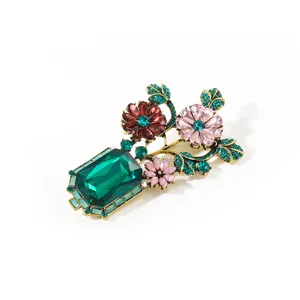 Vintage crystal vase brooch close up, colorful rhinestones inlay on retro gold metal alloy.