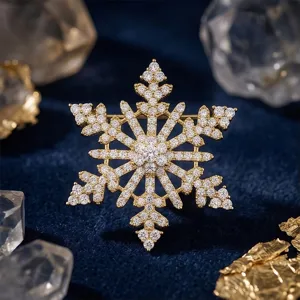 Gros plan détaillé de la magnifique broche flocon dorée, incrustation de strass brillants.
