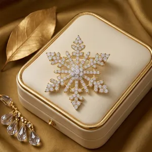 Gros plan d'une broche flocon de neige en cristal luxueuse sur un coffret à bijoux crème.