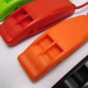 Plastic survival whistle with lanyard, dual-frequency design for outdoor emergency use.