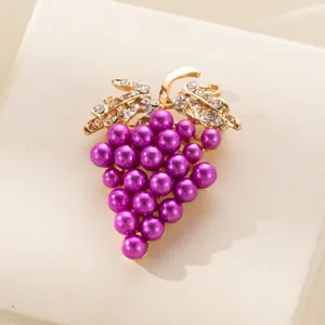 Dettaglio spilla uva perla, lega dorata con strass scintillanti sulle foglie.