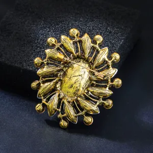 Vue détaillée de l'arrière d'une broche florale vintage dorée avec un mécanisme de fermoir.
