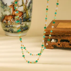 Detail shot of double-layered green sugar cube bead necklace with gold beads and chic style.