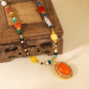 Detailed close-up of a vintage colorful beaded necklace with a large orange pendant.