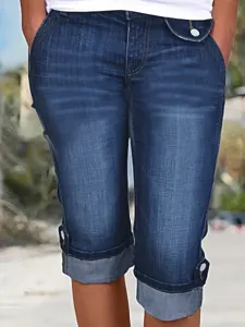 Detailed view of women plus size stretch denim capri pants with rolled cuffs and button accents.
