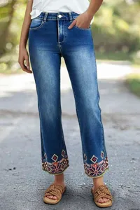 Detailed view of women's denim jeans featuring colorful embroidered cuffs and casual style.
