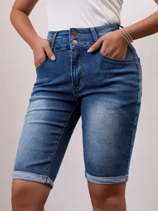 Close-up of women's high-waisted denim shorts, double button closure and rolled cuffs.