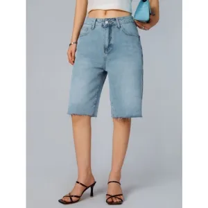 Détail de short en denim bleu clair pour femme, taille haute et ourlet brut stylé.