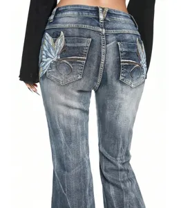 Detail view of women's slim stretch flared jeans featuring intricate butterfly embroidery.