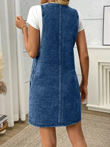 Detailed view of casual plus size denim jumper dress with white t-shirt, retro wash.