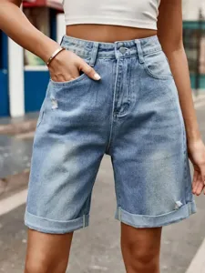 Close-up detail of high-waisted light blue denim shorts featuring stylish rolled cuffs and pockets.