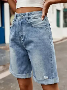 Detail view of high waist light blue denim shorts with rolled cuffs and classic five pockets.