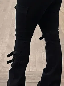 Nahaufnahme Detail der schwarzen Damen Cargo Schlagjeans mit Seitentaschen und Beingurten.